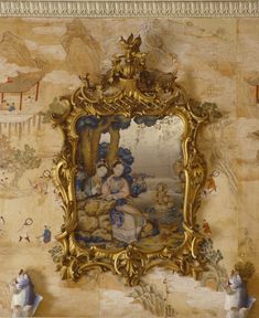 an ornately decorated wall with a mirror and figurines in front of it