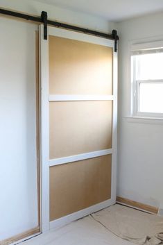 an empty room with a sliding door in the middle and some paint on the walls