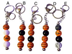 four different key chains with pumpkins and balls hanging from it's ends, all in different colors