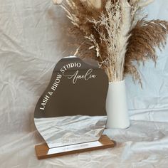 a vase with dried flowers in it sitting next to a plaque that reads las cabanara america