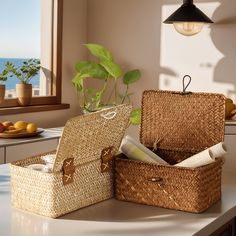 two wicker baskets sitting on top of a white counter next to a potted plant