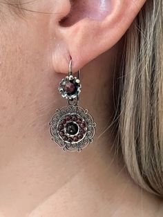 We are excited to feature a collection of Mexican Silver Filigree Earrings from Oaxaca in our store. Each piece is crafted from molten silver, processed and formed into intricate designs, often adorned with exquisite stones. Our artisans, with their skilled hands, create unique pieces that encapsulate a stunning and romantic aesthetic. Adorning these pieces, you're not just wearing jewelry; you're embodying a special, timeless elegance. Materials:  Oxidized Pure 92.5 Sterling Silver Gemstone: Amethyst Drop Length: 1 1/2" long, 1" wide Closure: Ear Wire Adjustable Filigree Earrings, Traditional Brown Teardrop Jewelry, Ornate Filigree Festival Earrings, Artisan Dangle Filigree Earrings, Artisan Dangle Earrings With Intricate Design, Artisan Drop Earrings With Intricate Design, Adjustable Filigree Dangle Earrings, Traditional Brown Nickel-free Jewelry, Artisan Brown Pierced Earrings