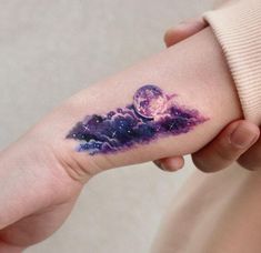 a woman's arm with a tattoo on it that has an image of the moon and stars