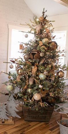 a decorated christmas tree in a bucket on the floor