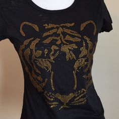 a women's black t - shirt with gold designs on it