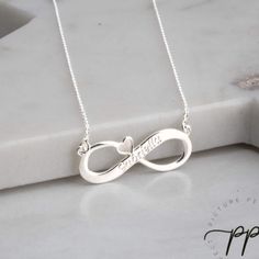 The infinity name necklace with a heart looks beautiful and stands out. The infinity has been designed to include the cut-out hearty, giving this infinity some added dimension and beauty. In addition to that, this infinity can be engraved with any name or word up to 15 characters long - so you can make it personalized. The infinity sits on a split chain, enabling us to ensure that the infinity stays on the neck in the right place. MATERIALS: Both the pendant and chain are made using sterling sil Valentine's Day Infinity Jewelry With Custom Name, Custom Name Infinity Necklace For Valentine's Day, Infinity Necklace For Valentine's Day Personalized Gift, Silver Infinity Name Necklace, Silver Engraved Infinity Necklace, Sterling Silver Infinity Necklace For Valentine's Day, Infinity Heart Charm Necklace For Valentine's Day, Heart Charm Infinity Necklace For Valentine's Day, Engraved Infinity Jewelry For Valentine's Day