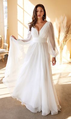 a woman in a white wedding dress posing for the camera