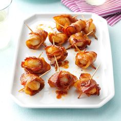 small appetizers are arranged on a plate with toothpicks wrapped in bacon