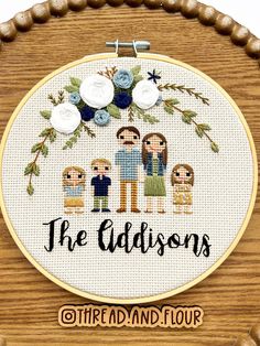 the addisons cross stitch pattern on a wooden frame