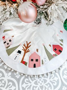 an ornament hanging from a christmas tree with ornaments around it on the floor