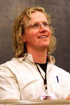 a man with glasses sitting at a table