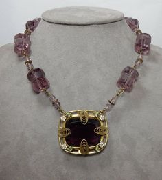 "Here's a wonderful vintage Czech necklace featuring amethyst beads and stones. The large barrel shaped beads along the chain have a spiraling floral design etched into them. The center pendant with dark amethyst stone has tiny enamel flowers on the border and large oval shaped filigree prongs holding it in place. Measures 16\" long and has a spring-ring clasp. Exceptional vintage condition with no chips. Thanks for looking." Collectible Amethyst Necklace In Purple, Vintage Amethyst Purple Jewelry, Collectible Amethyst Purple Necklace, Collectible Purple Amethyst Necklace, Vintage Purple Amethyst Jewelry, Vintage Purple Beaded Necklace, Purple Beaded Vintage Necklace, Purple Vintage Beaded Necklace, Purple Amethyst Necklace For Collectors