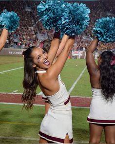 the cheerleaders are all dressed in white and blue pom - poms