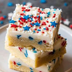 three pieces of cake sitting on top of a white plate with red, white and blue sprinkles