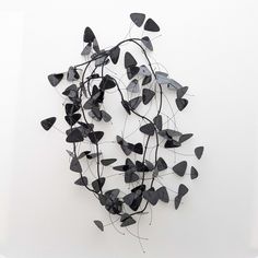 a group of black butterflies on a white wall