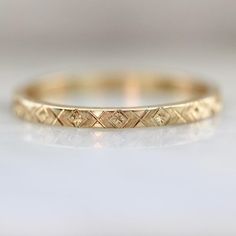 a yellow gold wedding band with diamonds on the inside and outside, sitting on a white surface