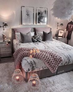 a bed with pillows and blankets on top of it in a room filled with lights