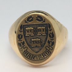 Vintage 14K Gold 1989 Class Ring Harvard University 11.7 Gram Size 7.75 This vintage 14K gold class ring from Harvard University is a timeless piece of jewelry that is perfect for any occasion. Crafted by Jostens in 1980s, this ring features a beautiful design that captures the essence of collegiate style. The ring is made of yellow gold and is purified to 14K, making it a valuable addition to any jewelry collection. The ring is sized at 7.75 and is suitable for men. Its color is gold, and it fe 1983 Ladies Gold Class Ring, 1976 Class Ring, College Rings, Class Rings, Gold Class, Collegiate Style, School Theme, Harvard University, School Themes