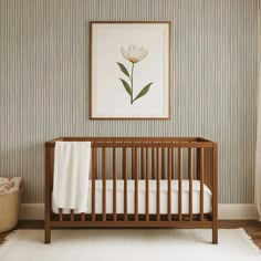 a baby's crib in front of a wall with a flower on it