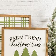 farm fresh christmas trees sign in front of a white brick wall with pine tree silhouettes