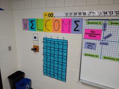 a classroom with colorful bulletin boards and trash cans on the wall next to a black trash can