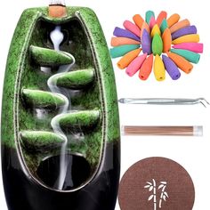 a green vase with water flowing out of it, surrounded by crafting supplies and tools