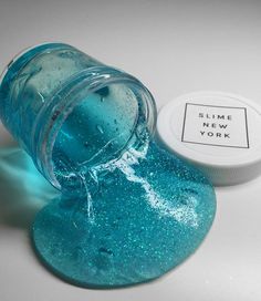 a jar with blue glitter on it next to a white container that says slime new york