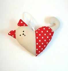 a white and red cat ornament with polka dots