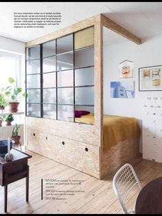 a room with a bed, desk and chair next to a wall mounted bookcase