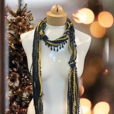 Discover this stunning bohemian beaded scarf necklace, crafted from luxurious Italian mohair yarn. The perfect lightweight accessory to elevate your holiday style. Features: Black and gold color combination Mohair yarn Italian craftsmanship Lightweight and comfortable Beaded details Linen gift pouch Benefits: Adds a touch of bohemian elegance to any outfit Perfect for the holiday season Luxurious and high-quality materials Versatile and can be worn in multiple ways Makes a thoughtful and stylish Bohemian Black Handmade Scarves, Bohemian Black Handmade Scarf, Black Bohemian Scarf For Festive Occasions, Black Bohemian Scarves For Festive Occasions, Bohemian Handmade Scarves For Festive Occasions, Handmade Black Scarves As Gifts, Handmade Bohemian Scarves For Festive Occasions, Gold Color Combination, Beaded Scarf