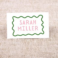 a white card with pink and green writing that says,'sarah miller '