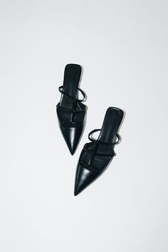 Salma features a pointed toe, low kitten heel, and a strappy upper in a matte black vegan leather. The perfect mules. Size and Fit Information: U.S. Sizing Available in whole and half sizes Runs true to size (Note: Not using leather and other materials from animals significantly reduces environmental impact, however, we acknowledge that synthetic alternatives are not without environmental concerns. As we grow, we are dedicated to finding alternative materials that are even safer for the planet.) Composition: 1.5"/40 mm heel Sole: Rubber 100% Vegan, Animal and Cruelty-Free Imported Chic Black Kitten Heels With Single Toe Strap, Black Kitten Heels With Single Toe Strap For Evening, Pointed Toe Mules For Evening In Fall, Black Single Toe Strap Kitten Heels For Spring, Black Kitten Heels With Single Toe Strap For Spring, Black Sleek Mules With Single Toe Strap, Sleek Black Mules With Single Strap, Black Pointed Toe Mules, Black Mules With Sculpted Flat Heel