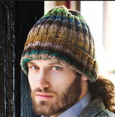 a man with long hair wearing a knitted hat