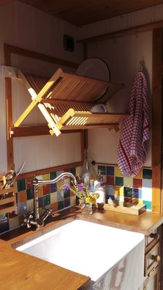 a kitchen sink sitting under a wooden shelf