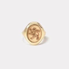 a gold signet ring with an image of a lion on the front and side