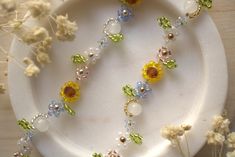 a white plate topped with lots of beads and flowers