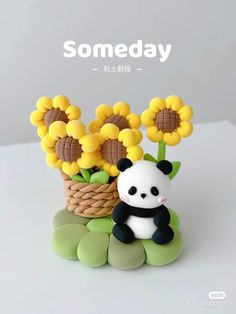 a panda bear sitting on top of a basket with sunflowers in it's mouth