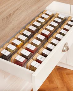 a drawer filled with different types of condiments on top of a wooden floor