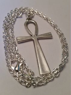 "Antique Silver Ankh Cross on a Silver Plated 24\" Chain. *Cross is 2\" Long and 1 1/8\" Wide Ankh is lightweight and comfortable to wear . May Choose Chain Length during checkout; 20\" 22\" 24\" Ankh Cross; The Ankh is also known as key of life, the key of the Nile or crux ansata (Latin meaning \"cross with a handle\"), was the ancient Egyptian hieroglyphic character that read \"eternal life\". Egyptian gods are often portrayed carrying it by its loop, or bearing one in each hand, arms crossed Symbolic Metal Chain Necklace, Symbolic Metal Necklace With Silver Chain, Spiritual Pendant Metal Chain Necklace, Spiritual Metal Pendant Chain Necklace, Spiritual Pendant Chain Necklace, Symbolic Metal Snake Chain Necklace, Symbolic Snake Chain Necklace, Symbolic Metal Necklace With Lobster Clasp, Symbolic Silver Pendant Chain Necklace