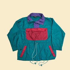 "Vintage pullover windbreaker jacket, manufactured ca. 1980s by Red Pepper Action Wear. Features a big front pouch, two side pockets, and a drawstring at waist and hem.    - Brand: Red Pepper Action Wear    - Size: L    - Time Period: 1980s    - Color(s): Purple, teal green, pink    - Materials: Nylon    - Made in: Macau    - Condition: In good vintage condition, with some minor markings on the back and a few loose threads (see photos with hand). Measurements (see sizing chart in last photo): Retro Hiking Windbreaker With Pockets, 90s Color Block Windbreaker For Outdoor, Retro Nylon Windbreaker With Pockets, Retro Green Nylon Windbreaker, Vintage Winter Color Block Windbreaker, 80s Windbreaker, Vintage Tracksuit, 90s Red Sports Windbreaker, Vintage Multicolor Windbreaker With Pockets