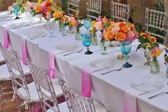 the table is set with many different colored flowers