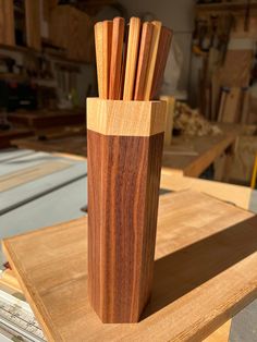 a wooden vase with several sticks sticking out of it's sides on a table