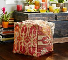 a wooden trunk sitting on top of a hard wood floor next to a vase filled with flowers