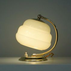 a table lamp with a white glass shade on it's base and a metal stand