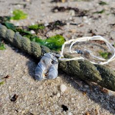 Unique, ocean carved shell in dark gray tones wrapped in silver stainless steel wire. Chain is 16" tan and white cord.  Shell pendant:  1" W x 1.5" L Adjustable Silver Shell Necklace, Adjustable Silver Shell Necklace As Gift, Adjustable Silver Shell Necklace For Gift, Unique Adjustable Silver Shell Necklace, Williamsburg Va, Gray Tones, Carved Shell, Stainless Steel Wire, Grey Tones