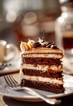 a slice of chocolate cake on a plate with a fork and coffee cup in the background