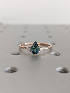 a close up of a ring with a blue stone and diamonds on the side,