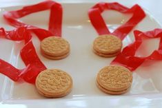 three cookies on a plate with red ribbon around them