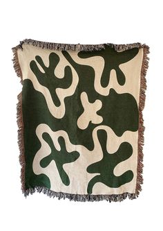 a green and white camouflage print pillow with fringes on the edges, in front of a white background