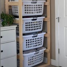 three baskets are stacked on top of each other in the corner of a room with an open door